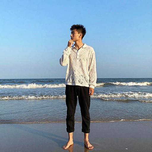 Young man standing on beach at sunset