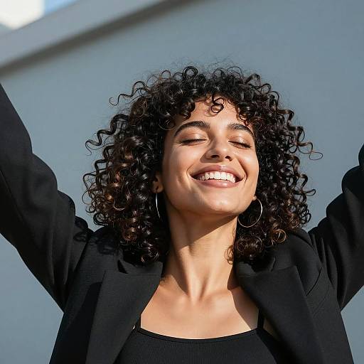 Joyful Woman with Curly Hair in Black Jacket