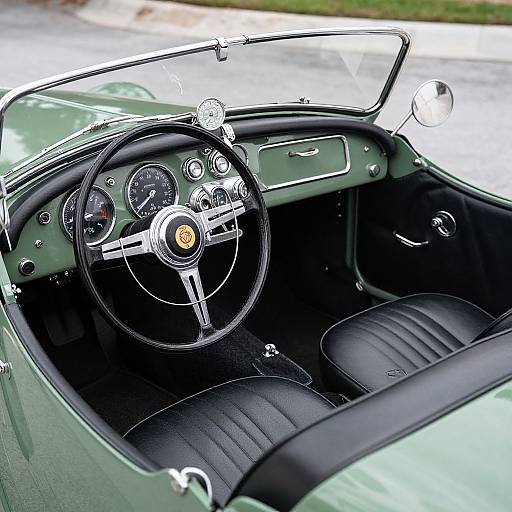 Photograph of a classic green convertible's interior, showcasing a black leather-wrapped steering wheel, vintage gauges, and black leather seats.