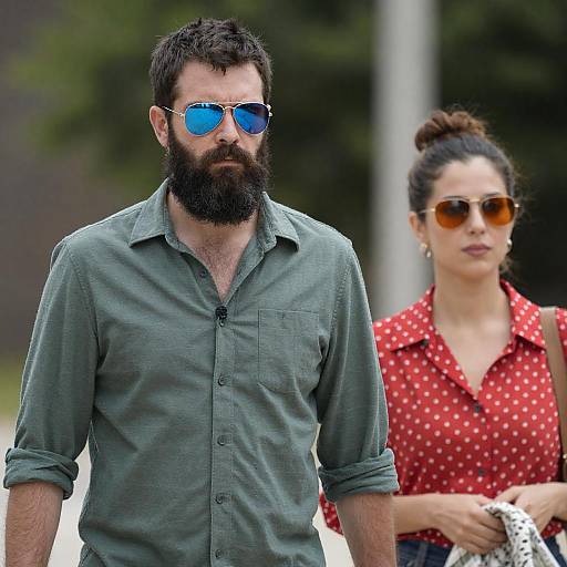 Man and Woman Walking Outdoors Wearing Sunglasses