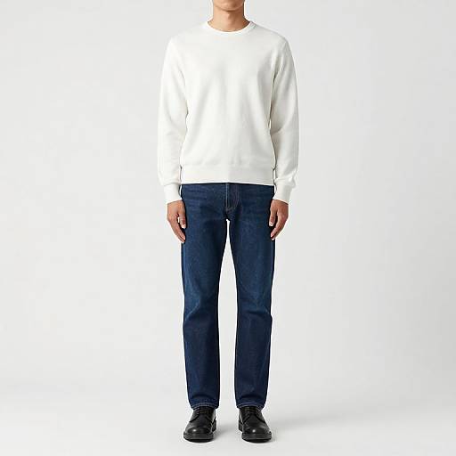 Photograph of a person in a white sweatshirt, dark blue jeans, and black shoes, standing against a plain white background.