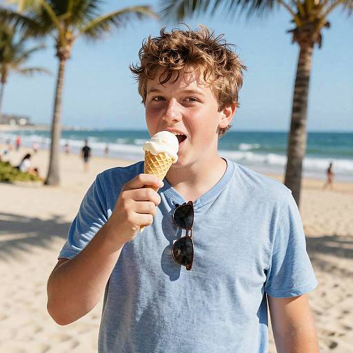 Photograph of a young boy with messy brown hair, wearing a light blue t-shirt and sunglasses around his neck, licking a vanilla ice cream cone on