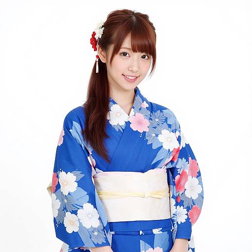 Photograph of a smiling Asian woman with long brown hair in a red flower clip, wearing a blue floral kimono with white and pink flowers, and