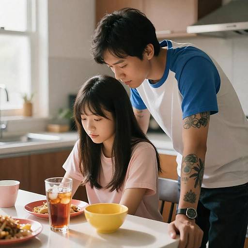 Tattooed Man Leaning Over Woman in Kitchen