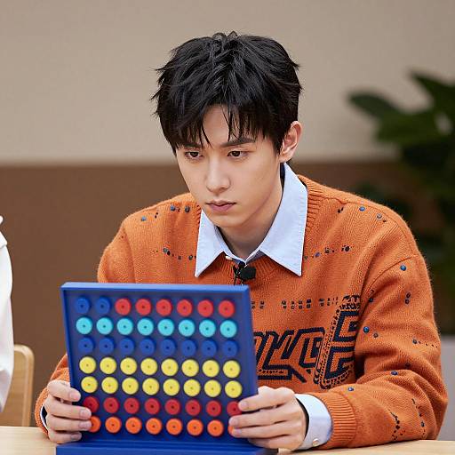 Serious Young Man with Colorful Game Board