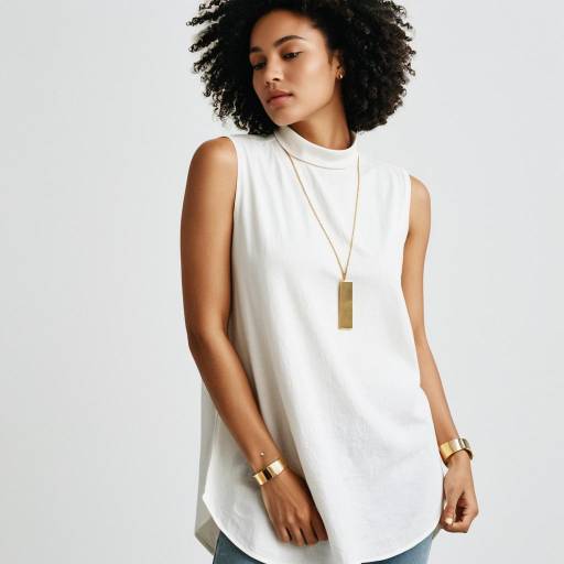 Woman Wearing Sleeveless White Tunic and Gold Jewelry