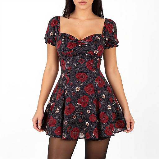 Photograph of a woman wearing a black, short-sleeved, V-neck floral dress with red and white roses, and black tights, against