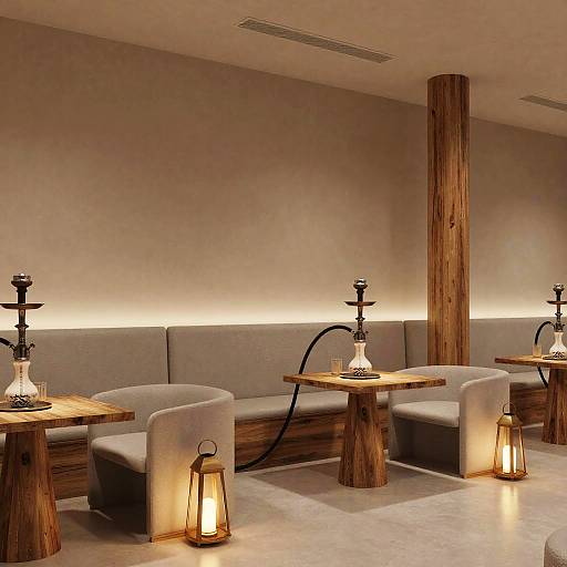 Photograph of a modern, minimalist café with wooden tables, grey upholstered seats, shisha pipes, and warm-lit lanterns on the floor