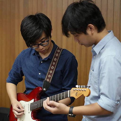 Young Men Tuning a Red Electric Guitar