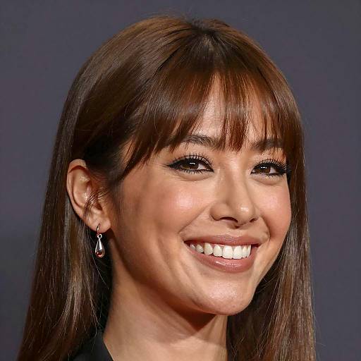 Smiling woman with straight brown hair and silver earrings