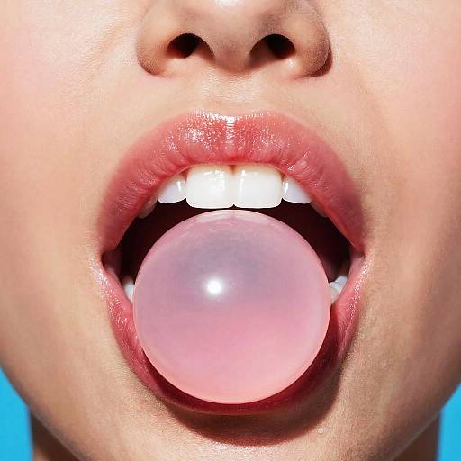 Close-up photograph of a person's face, focusing on their slightly parted lips with a large, pink bubble gum ball in their mouth, against a bright