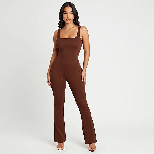 Photograph of a confident, curvy woman with medium skin tone, black wavy hair, wearing a form-fitting, dark brown sleeveless jumps