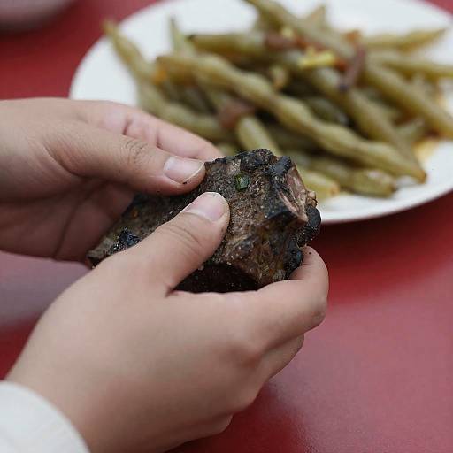 Hands Gripping a Meaty Object on Table
