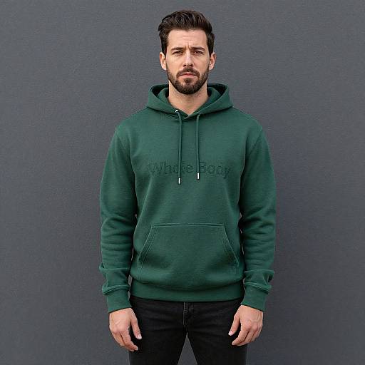 Photograph of a bearded man with short dark hair, wearing a green 