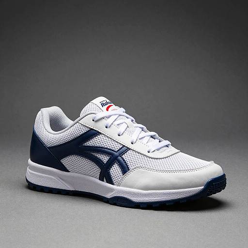 Photograph of a white athletic sneaker with black mesh accents, laces, and stripes, set against a gray gradient background.