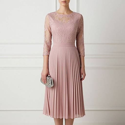 Photograph of a woman in a pink lace long-sleeve dress with a pleated skirt, holding a sparkly clutch, standing against a white