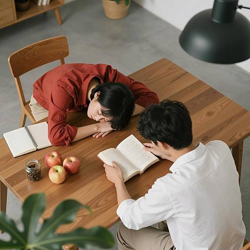 Overhead View of Two People Studying at Wooden Table