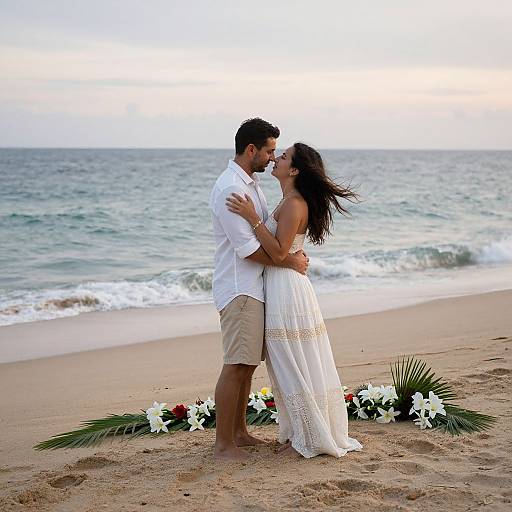 Photograph of a bearded man in white shirt and khaki shorts, embracing a brunette woman in white dress, kissing on a beach with ocean background