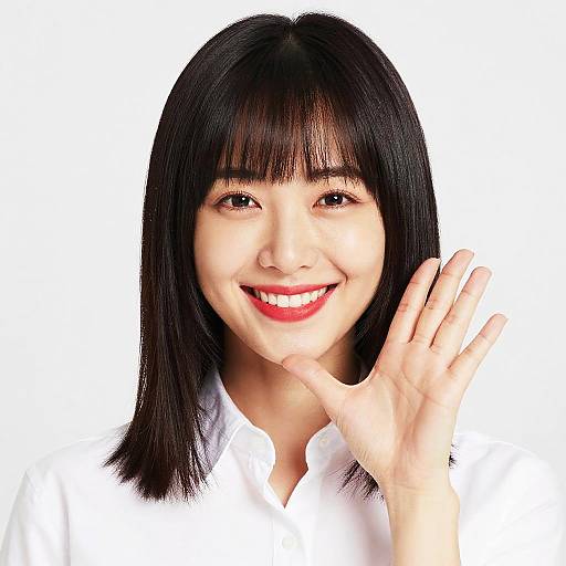 Photograph of smiling Asian woman with straight black hair, wearing a white shirt, waving with her right hand against a white background.