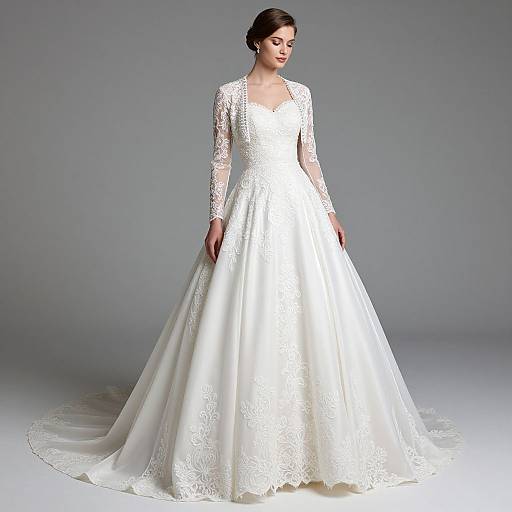 Photograph of a young woman with dark hair in an elegant white lace wedding gown with long sleeves, standing against a plain gray background.