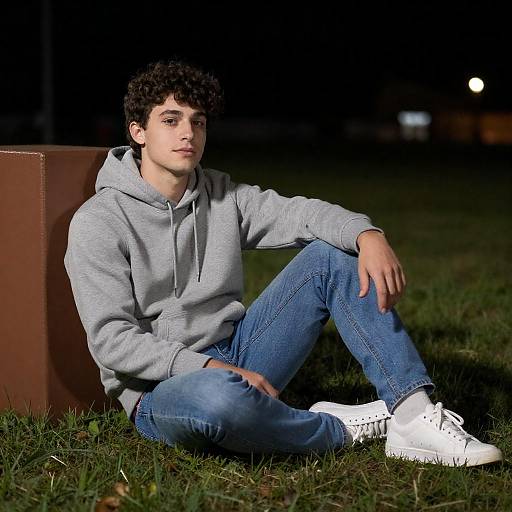 Young Man Sitting on Grass at Night