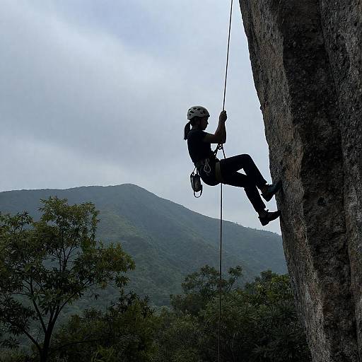 Silhouetted Rock Climber Against Mountain Backdrop