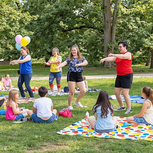 Photograph of diverse group playing outdoor Simon Says game in sunny park; children and adults, colorful clothes, balloons, and patterned blankets.