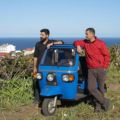 Two Men by Blue Three-Wheeled Vehicle