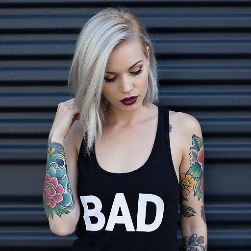 Photograph of a blonde woman with white hair, dark lipstick, black tank top with 