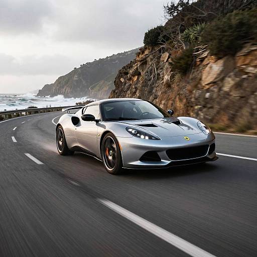 Photograph of a sleek, silver Ferrari 458 Italia speeding along a coastal road, with rocky cliffs and ocean waves in the background.