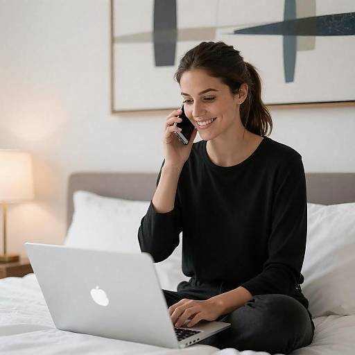 Smiling Woman on White Bed with Laptop