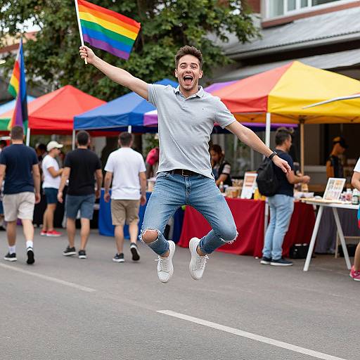 Photograph of a joyful, young man with short brown hair, wearing a white polo and ripped jeans, mid-jump, waving a rainbow flag,