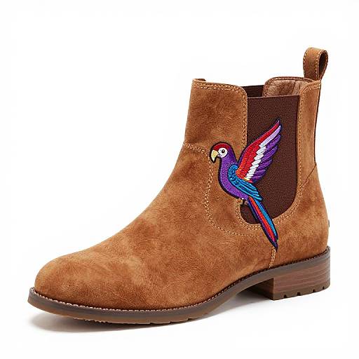 Photograph of a brown suede ankle boot with a colorful embroidered bird on the side, dark brown inner lining, and a wooden heel.
