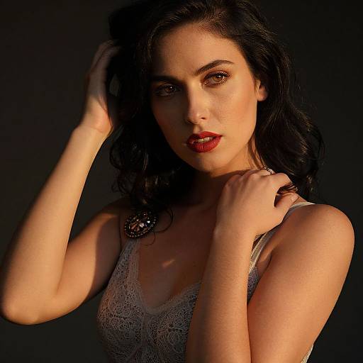 Photograph of a beautiful woman with dark wavy hair, red lipstick, and lace tank top, illuminated against a black background.