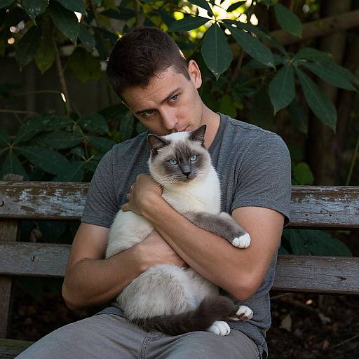 Photograph of a muscular man with short dark hair, wearing a gray t-shirt and jeans, sitting on a wooden bench, hugging a blue-eyed