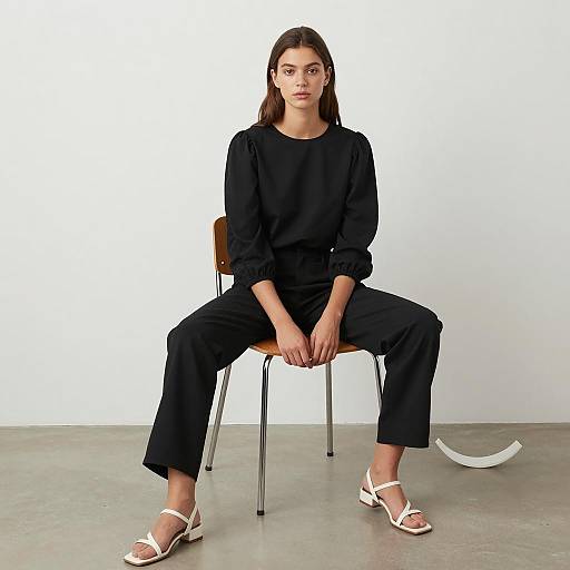 Young Woman Sitting in Black Outfit and White Sandals