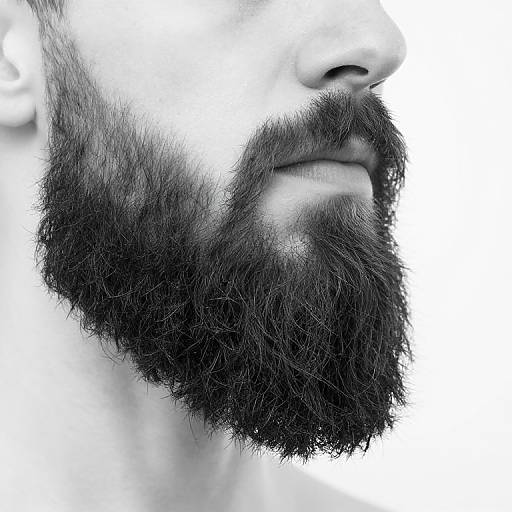 Close-up photograph of a man's bearded face, showing a thick, black, full beard and part of his nose and lips, against a white