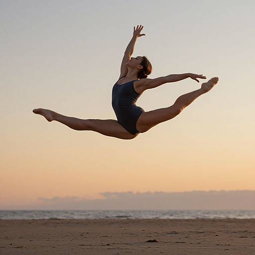 Photograph of a woman in a navy leotard mid-air performing a high kick against a sunset beach background with a calm ocean.