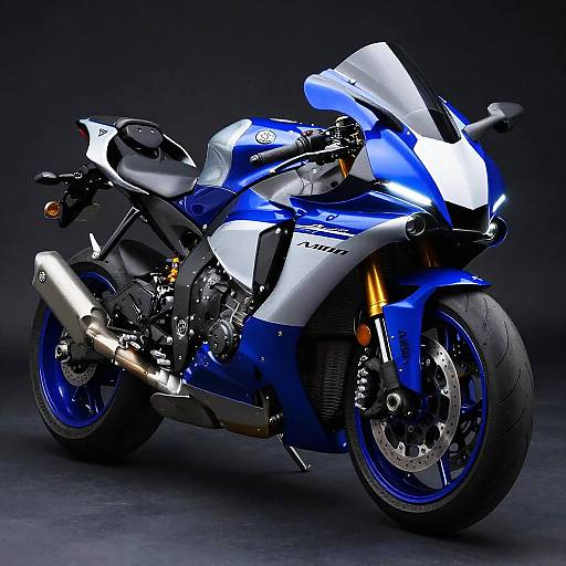 Photograph of a sleek, blue and white Yamaha sport motorcycle with glossy finish, black seat, and illuminated headlights against a dark background.