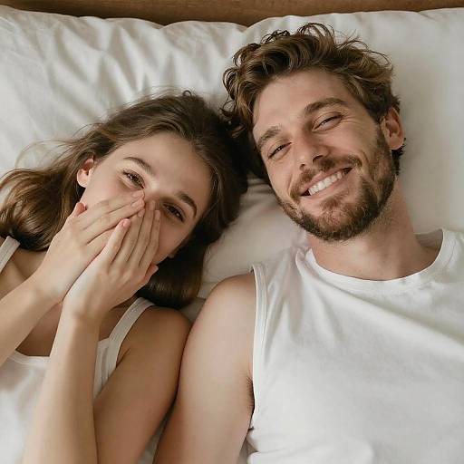 Smiling Couple in Bed Under Soft Light