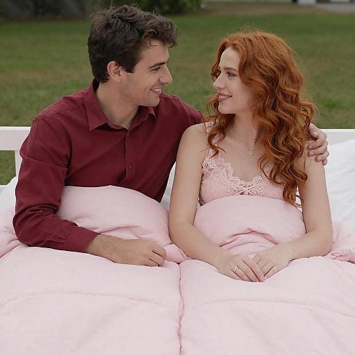 Joyful Couple Relaxing Under Pink Quilt