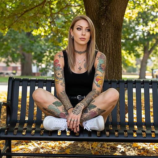 Tattooed Woman Relaxing in Sunlit Park