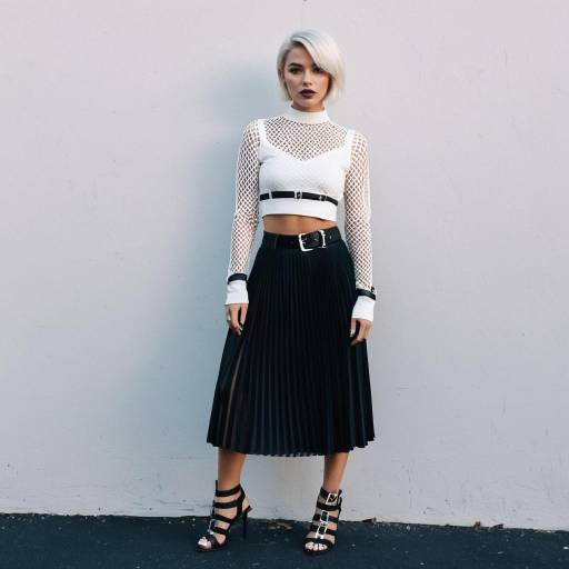 Edgy Woman in White Mesh Crop Top and Black Pleated Skirt