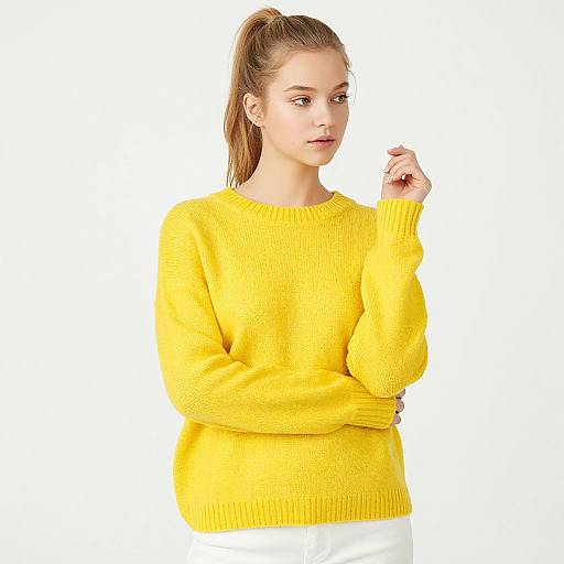Photograph of a young woman with fair skin and brown hair in a ponytail, wearing a bright yellow knit sweater, standing against a white background.