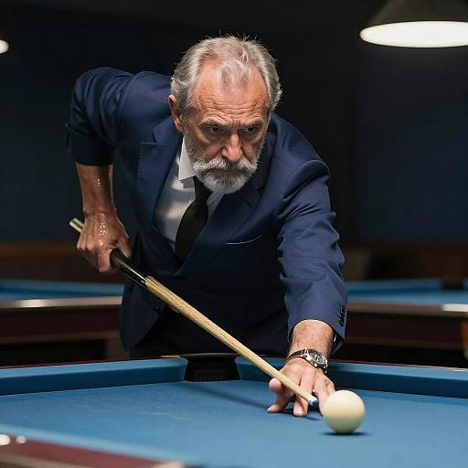 Photograph of an elderly man with a gray beard in a dark suit, leaning over a blue pool table, aiming a cue stick at a white ball