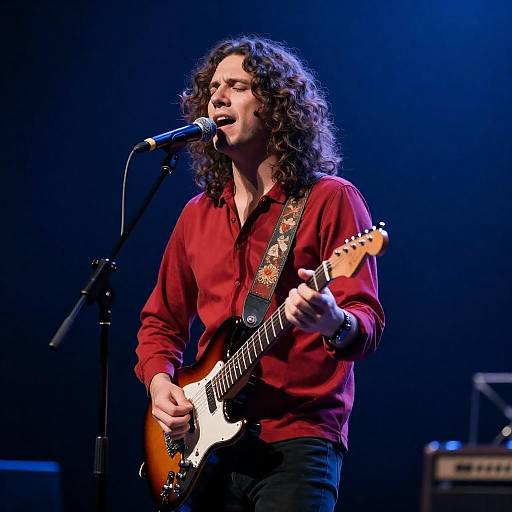 Passionate Guitarist Singing on Blue Stage