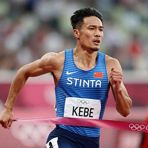 Photograph of a muscular Asian male sprinter in a blue 