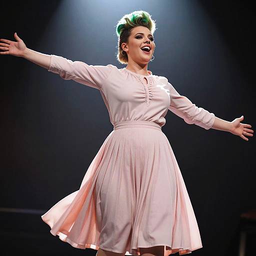 Photograph of a woman with green-styled hair, wearing a white, long-sleeve, knee-length dress, dancing with arms outstretched