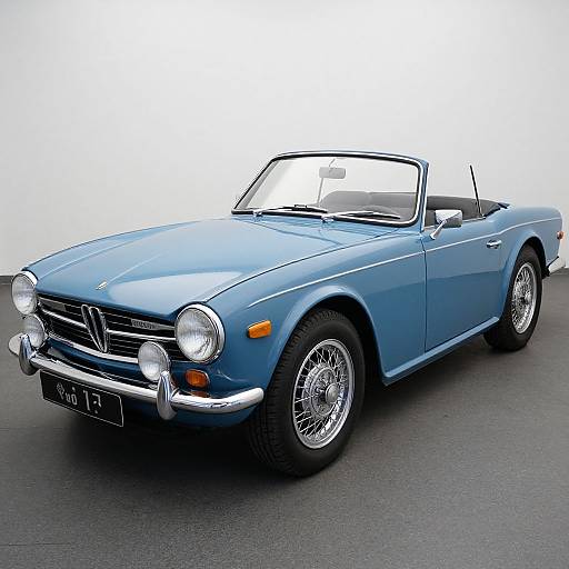 Photograph of a classic blue Volkswagen convertible with white top, chrome bumper, round headlights, and wire-spoke wheels, parked on an asphalt surface.