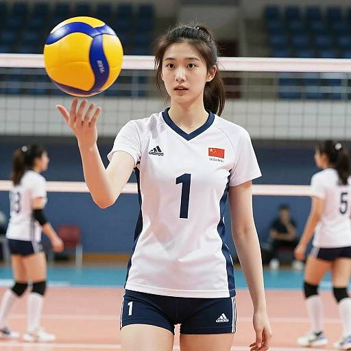 Photograph of an Asian female volleyball player in a white jersey with number 1, black shorts, and black knee socks, catching a yellow and blue